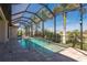 Screened-in rectangular pool with a spa, surrounded by lush landscaping at 669 Monaco Dr, Punta Gorda, FL 33950