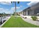 Canal-front home with a large grassy area, tropical landscaping, and a screened patio at 1700 Los Alamos Dr, Punta Gorda, FL 33950