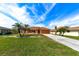 Attractive ranch home with palm trees, a manicured lawn, and a long driveway at 4115 Rock Creek Dr, Port Charlotte, FL 33948