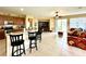 Open concept kitchen and living area with tile flooring, and breakfast bar at 24479 Vienison Ln, Punta Gorda, FL 33955