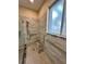 Walk-in shower with tiled walls, built-in seat, and grab bars at 24479 Vienison Ln, Punta Gorda, FL 33955