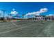 Tennis court with shade structure and clubhouse in background at 17130 Jadestone Ct, Venice, FL 34293