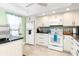 White kitchen with granite countertops and stainless steel appliances at 3600 Bal Harbor Blvd # 1G, Punta Gorda, FL 33950