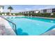 Community swimming pool with lounge chairs and palm trees at 3600 Bal Harbor Blvd # 1G, Punta Gorda, FL 33950