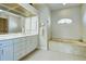 Bathroom featuring a marble encased tub, a large mirror, and white cabinets at 1429 Blue Jay Ct, Punta Gorda, FL 33950