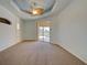 Bedroom boasting neutral carpet, sliding glass doors to the screened lanai with pool view and a decorative ceiling fan at 1429 Blue Jay Ct, Punta Gorda, FL 33950