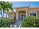Inviting front entrance with blue double doors, stone pillars, and lush tropical landscaping creating curb appeal at 1429 Blue Jay Ct, Punta Gorda, FL 33950