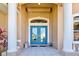 Elegant front entrance with double glass doors, stone pillars, and neutral tones, creating a welcoming ambiance at 1429 Blue Jay Ct, Punta Gorda, FL 33950