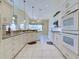Modern kitchen with white cabinetry, granite counters, tile floors, and stainless appliances, offering style and functionality at 1429 Blue Jay Ct, Punta Gorda, FL 33950