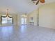 Open-concept living room with tile flooring, high ceilings, elegant lighting, and access to foyer and kitchen at 1429 Blue Jay Ct, Punta Gorda, FL 33950