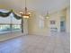 Bright living room with tile flooring, elegant chandelier, and large windows with decorative curtains at 1429 Blue Jay Ct, Punta Gorda, FL 33950