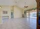 Spacious living room featuring tile flooring, high ceilings, ceiling fan, and views of the screened lanai and pool at 1429 Blue Jay Ct, Punta Gorda, FL 33950
