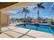 Inviting screened pool area overlooking the canal, with tropical plants and comfortable seating for relaxation at 1429 Blue Jay Ct, Punta Gorda, FL 33950