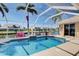 Screened in pool with a dolphin mosaic, palm trees and a beautiful view of the canal at 1429 Blue Jay Ct, Punta Gorda, FL 33950