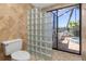 Bathroom with glass block shower, toilet, and access to a private patio at 5081 San Rocco Ct, Punta Gorda, FL 33950
