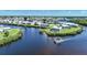 Aerial view of a waterfront community with a boat sailing through the canal on a sunny day at 542 Tampico Dr, North Port, FL 34287