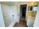 Clean bathroom with a tub, toilet, vanity with sink, and access to another room at 66 Wylam Dr, Port Charlotte, FL 33954