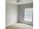 Bright bedroom with neutral walls and carpet, featuring a window with blinds and a ceiling fan at 66 Wylam Dr, Port Charlotte, FL 33954