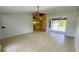 Spacious living area with tile floors, sliding doors to patio, and a ceiling fan at 66 Wylam Dr, Port Charlotte, FL 33954