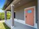 Front porch with coral-colored door and gray siding at 14242 Imlay Ave, Port Charlotte, FL 33981