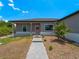 Front view of a single-story house with gray siding, a walkway, and landscaping at 14242 Imlay Ave, Port Charlotte, FL 33981
