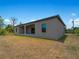 Rear view of a single-story house with covered patio and gray siding at 14242 Imlay Ave, Port Charlotte, FL 33981