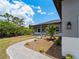 Side view of a single-story house with gray siding, a walkway, and landscaping at 14242 Imlay Ave, Port Charlotte, FL 33981