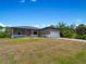 Exterior view of a single-story house with gray siding and landscaping at 14242 Imlay Ave, Port Charlotte, FL 33981