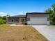 House exterior with gray siding, white garage door, and landscaping at 14242 Imlay Ave, Port Charlotte, FL 33981