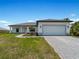 New home exterior, showcasing a white garage door and landscaped yard at 13409 Warba Ave, Port Charlotte, FL 33981