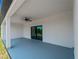 Covered back patio with gray flooring and ceiling fan at 13409 Warba Ave, Port Charlotte, FL 33981