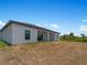 Single-story house with covered patio, grassy backyard, and mature trees at 13409 Warba Ave, Port Charlotte, FL 33981