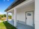 White door leading to the side patio, with gray concrete flooring and columns at 13409 Warba Ave, Port Charlotte, FL 33981