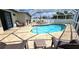 Inviting kidney-shaped pool with ample lounge chairs in screened enclosure at 22260 Aburto Ln, Port Charlotte, FL 33952