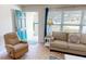 Bright living room featuring comfortable seating, large windows, and tile flooring at 22260 Aburto Ln, Port Charlotte, FL 33952