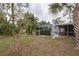 Peaceful backyard with screened pool, tropical plants, and grassy area at 20567 Midway Blvd, Port Charlotte, FL 33952