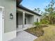 Side view of the front entrance with gray stucco siding and a covered porch at 12550 Mohican Ave, Port Charlotte, FL 33953