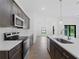 Modern kitchen with dark cabinets, white countertops and stainless steel appliances at 12550 Mohican Ave, Port Charlotte, FL 33953