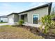 Side view of the house showcasing gray siding, a white garage door, and landscaping at 12550 Mohican Ave, Port Charlotte, FL 33953