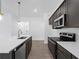 Modern kitchen with dark cabinetry, white countertops, and stainless steel appliances at 12550 Mohican Ave, Port Charlotte, FL 33953