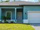 Teal home with gray door and paver driveway at 1417 Longson St, Port Charlotte, FL 33953