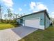 Newly built home with a teal exterior and paver driveway at 1417 Longson St, Port Charlotte, FL 33953