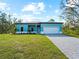 Newly built teal home with a paver driveway at 1417 Longson St, Port Charlotte, FL 33953