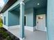 Front porch with teal walls, white door, and a white baseboard at 1417 Longson St, Port Charlotte, FL 33953