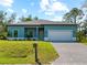 Newly built teal home with paver driveway and mailbox at 1417 Longson St, Port Charlotte, FL 33953