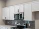 Modern kitchen with white cabinets and dark gray tile at 1417 Longson St, Port Charlotte, FL 33953
