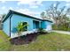 Teal house with landscaping and a white garage door at 1417 Longson St, Port Charlotte, FL 33953