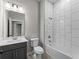 Modern bathroom with gray vanity, white tile, and bathtub at 1417 Longson St, Port Charlotte, FL 33953