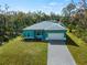 Aerial view of a teal home with a paver driveway at 1417 Longson St, Port Charlotte, FL 33953