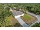 Aerial view of a home with a paved driveway surrounded by lush greenery and neighborhood streets at 3376 Dunbar St, Port Charlotte, FL 33948